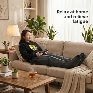 A person sitting back on a sofa wearing the black leg and foot massage boots and holding the wired handset
