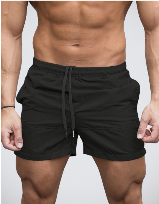 Dark blue lightweight beach shorts showing split side hem on model