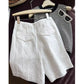White high waist linen shorts hung beside a striped knit top and sunglasses