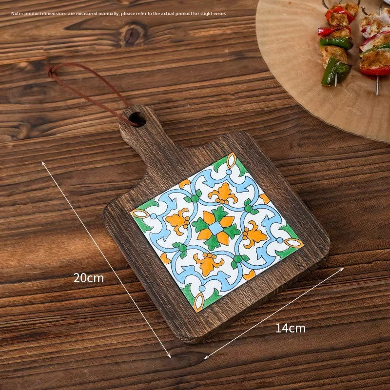 Wood trivet with an orange and green vine tile on planks, marked 20 cm by 14 cm