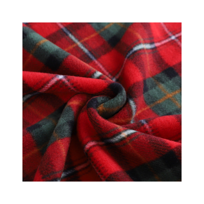 Swirled red, green and black tartan coral fleece fabric in a close up of the plaid pattern