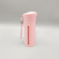 Pink four compartment travel bottle with a wrist strap and ml level window down the side