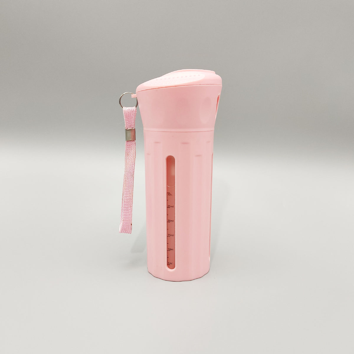 Pink four compartment travel bottle with a wrist strap and ml level window down the side