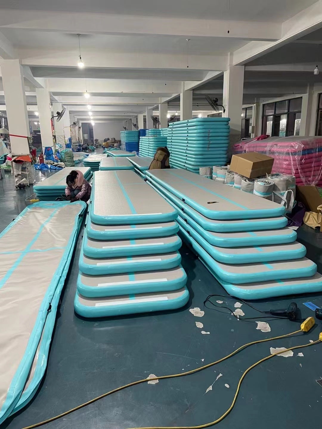 Stacks of mint green inflatable air track mats in a warehouse, 3 x 1 x 0.1 m option photo
