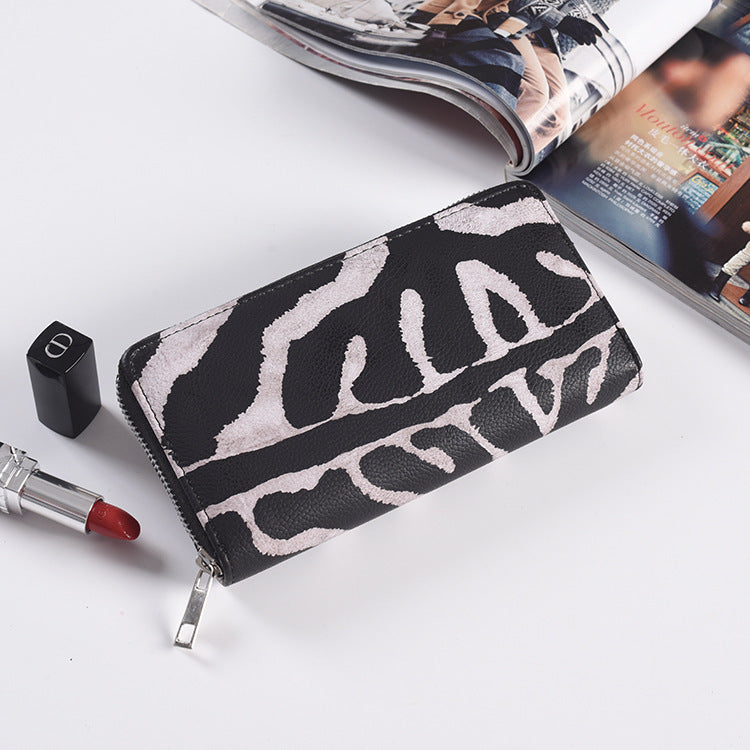 Close up of the zip pull and animal print PU face of the long wallet
