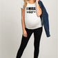 White maternity short sleeve tee with an I Miss Wine print, round neck and side ruching, on a pregnant model