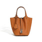Leather bucket tote bag resting against the side on the shoulder strap