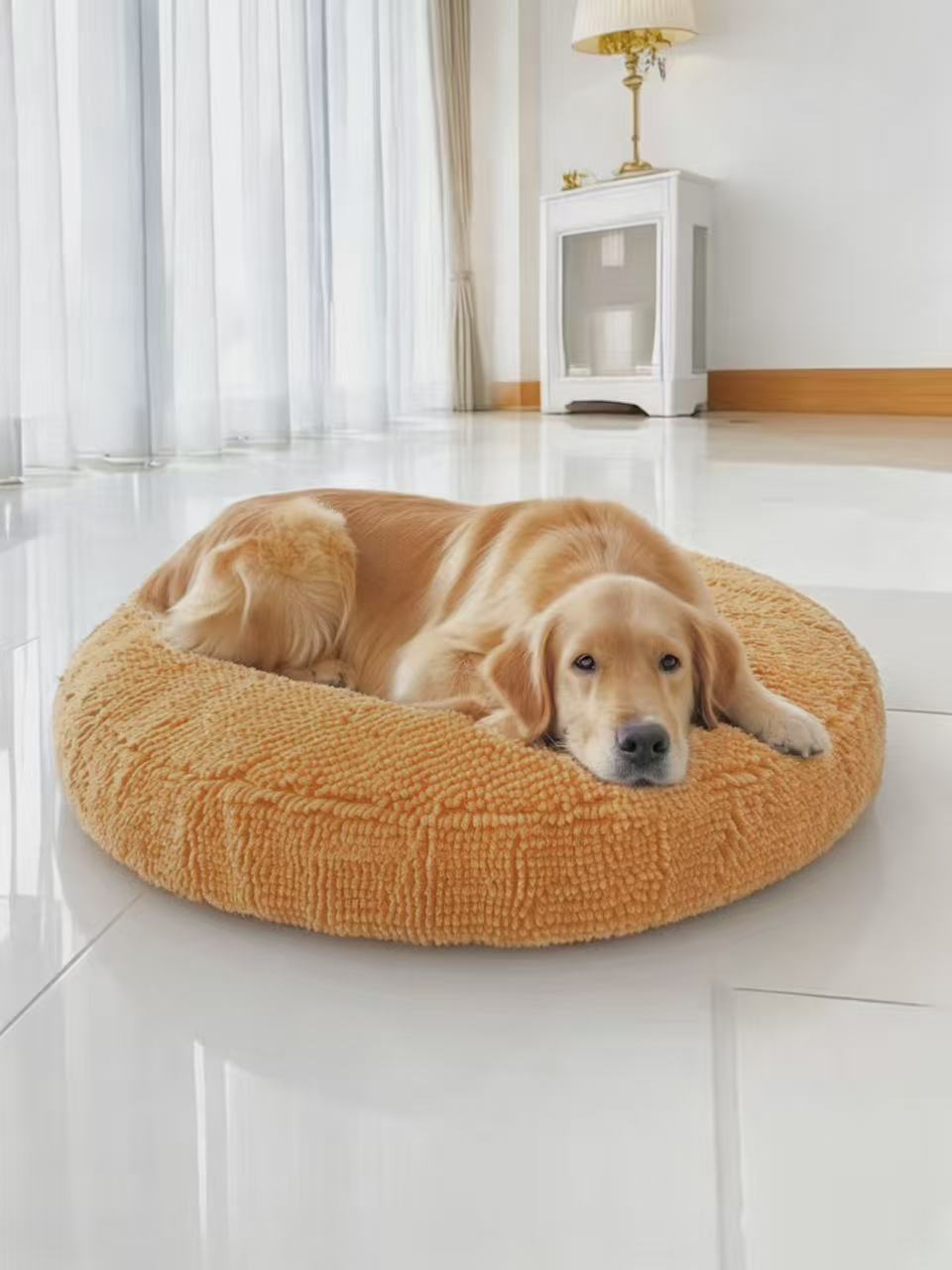Round pet bed with a raised chenille rim in a plain home setting