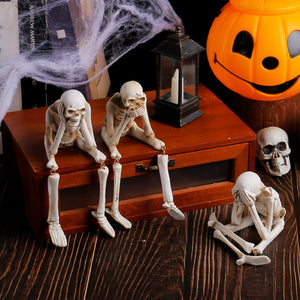 Skeleton shelf sitter figurine with legs dangling over a wooden edge