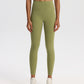 High-waisted stretch yoga leggings for women paired with white sneakers in studio