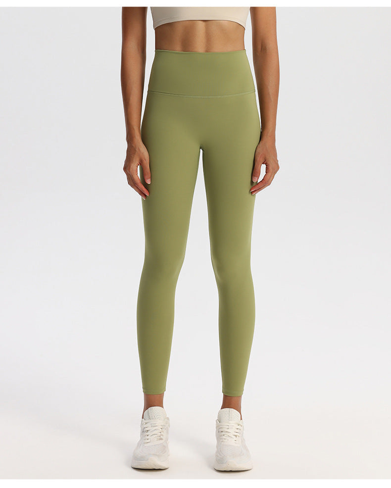High-waisted stretch yoga leggings for women paired with white sneakers in studio