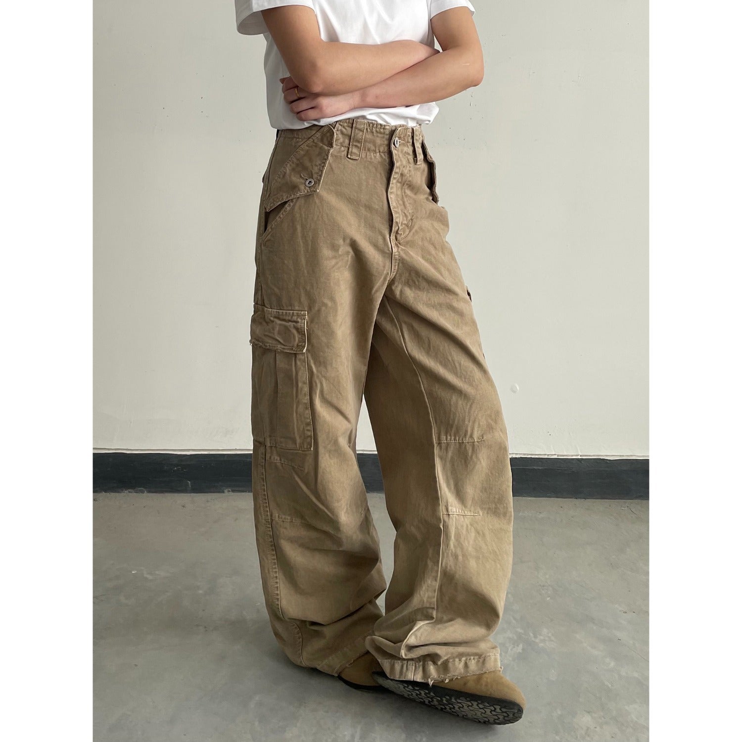 Faded khaki distressed pants styled with a plain tee for a casual look