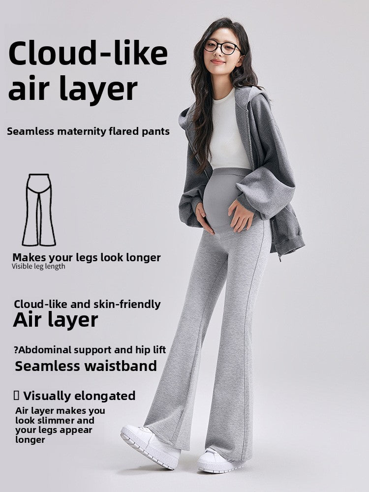 Heather gray maternity bell-bottom pants worn with a gray hoodie and white sneakers by a pregnant model