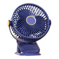 Blue clip fan on a plain background, three blades behind a round grille and gold hub ring