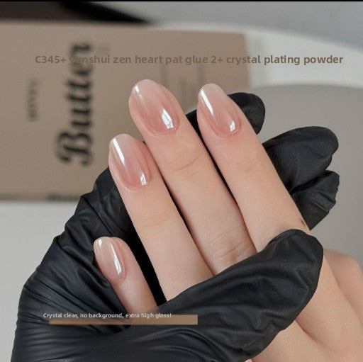 Hand in black glove showing glossy clear nude nails coated with crystal nail powder