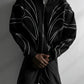 Front view of a black embroidered zip up hoodie laid on a bench