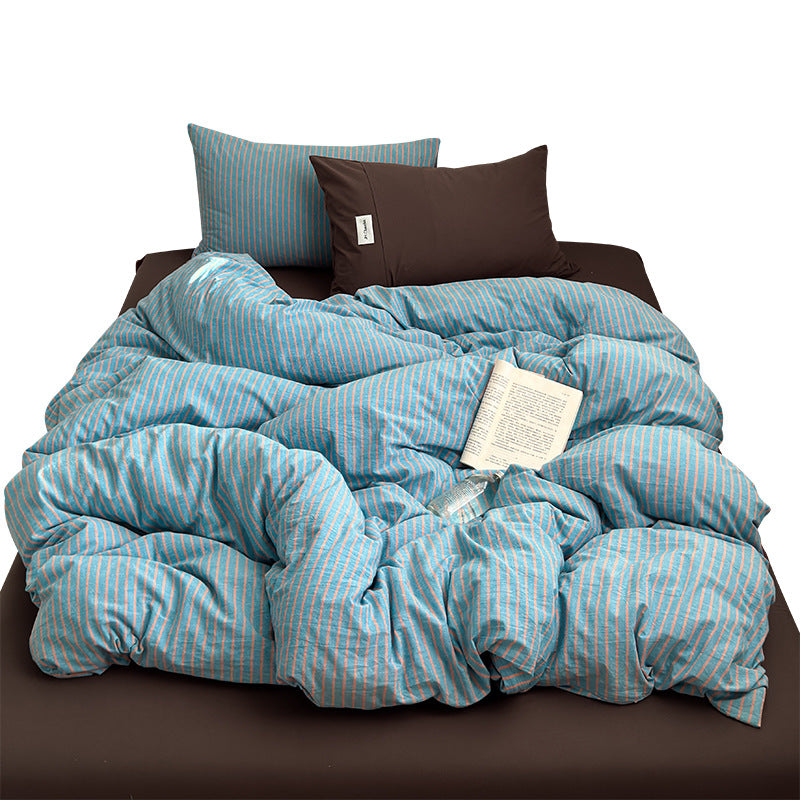 Blue and coral striped cotton bedding set with brown fitted sheet and pillowcase on a white background