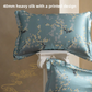 Teal blue silk pillowcase printed with white plum blossom branches and a bird, shown with a second case on a pedestal