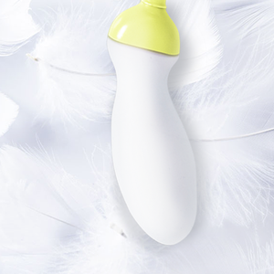 Close-up of the smooth white sensor with lime cap resting on soft white feathers