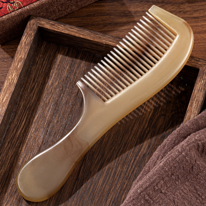 Full length view of the marbled amber plastic hair comb on a plain studio background