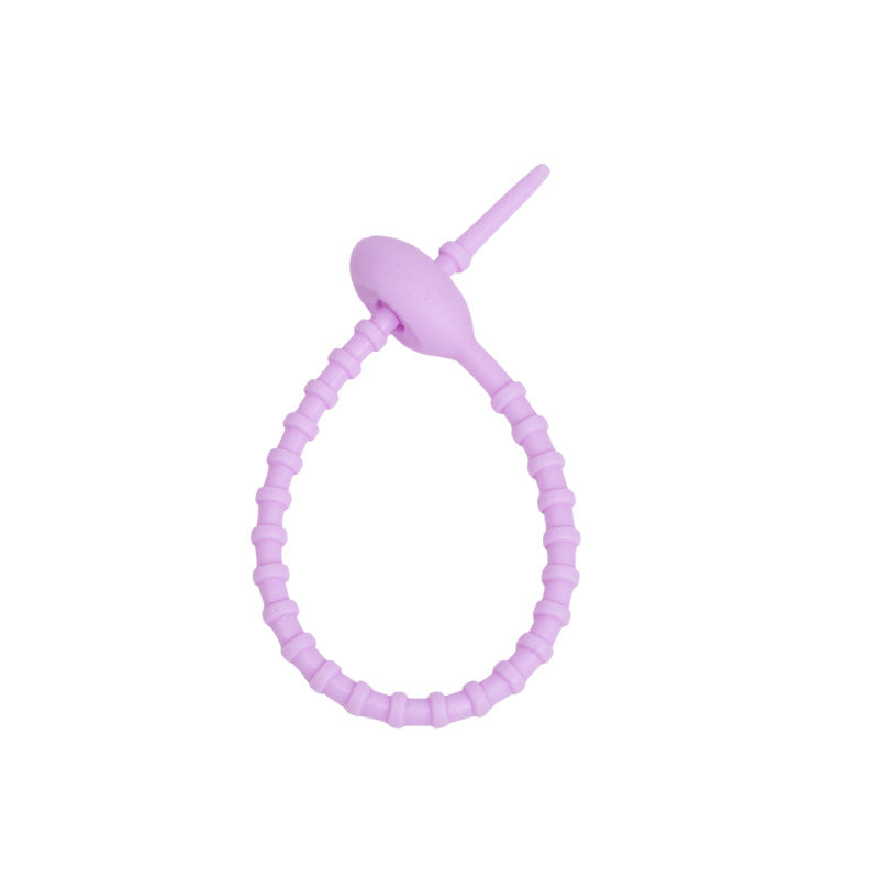 Flexible silicone cable tie shown open with the tail ready to thread through the head