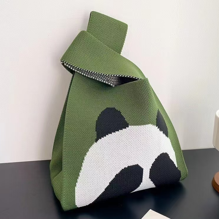 Two tone jacquard knit handbag carried by a built in wrist loop handle