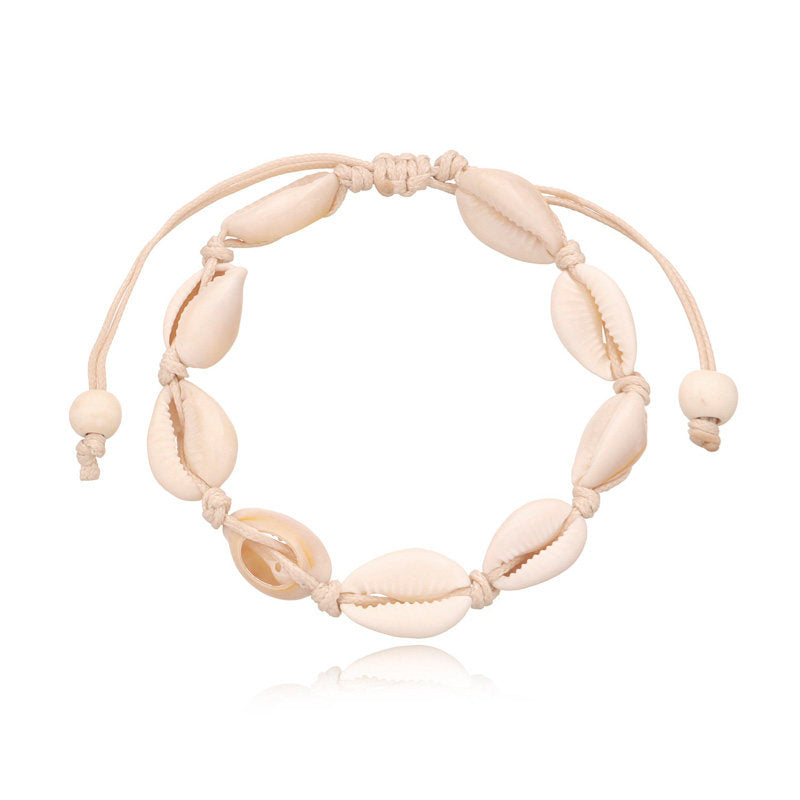 Cowrie shell anklet on a cream knotted cord with sliding tie ends and two bone tone beads