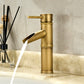 Antique copper bamboo basin faucet with a lever handle running water on a marble countertop