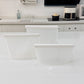 Three piece set of reusable clear silicone food storage bags standing sealed