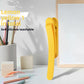 Single lemon yellow silicone bookmark clip standing on a desk beside a pen cup