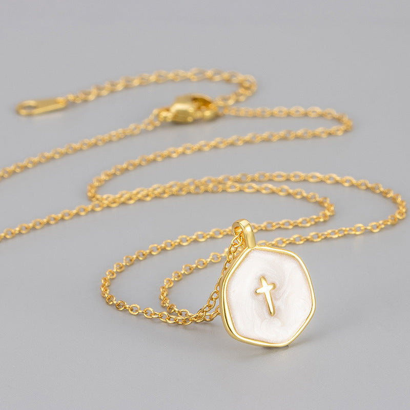 White marbled enamel gold plated cross pendant on a full gold tone cable chain with lobster clasp, flat lay