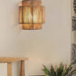 Lit stacked-tier hemp rope wall lamp on a pale wall beside a curtain, a wooden stool and a green plant