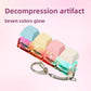Pastel keycap clicker keychain with colorful lit switches on a pink gradient