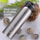 Natural silver stainless steel sports bottle with black flip lid lying on pebbles with water drops, silver option