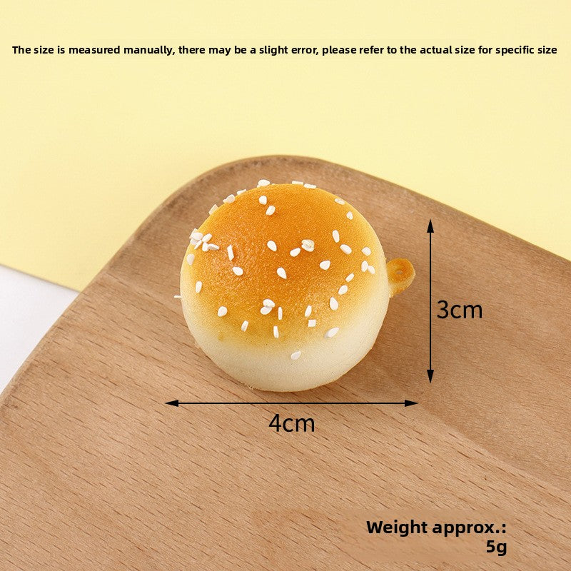 Golden bun squishy keychain clipped to a bag for a playful charm