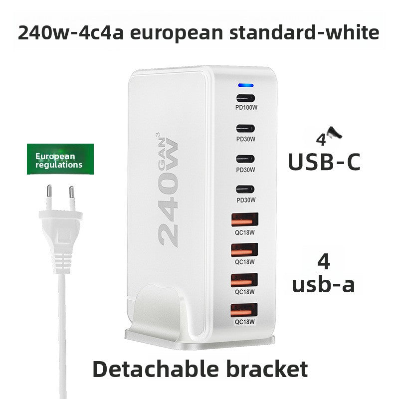 Multi port GaN charger displayed on a desk beside charging cables and a phone