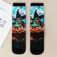 Pair of mid-calf socks printed with a skeleton witch stirring a glowing jack-o-lantern cauldron