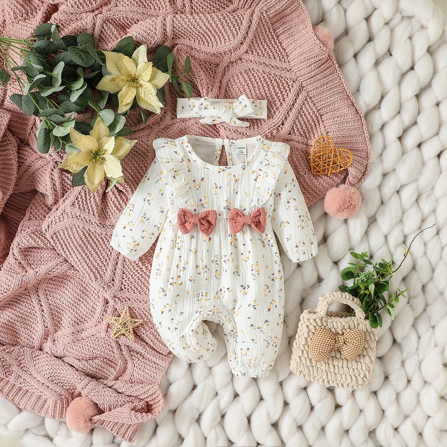 Baby floral romper laid out in a styled nursery interior scene