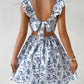 Floral square neck ruffle strap mini dress with a shirred bodice on a standing model, front view