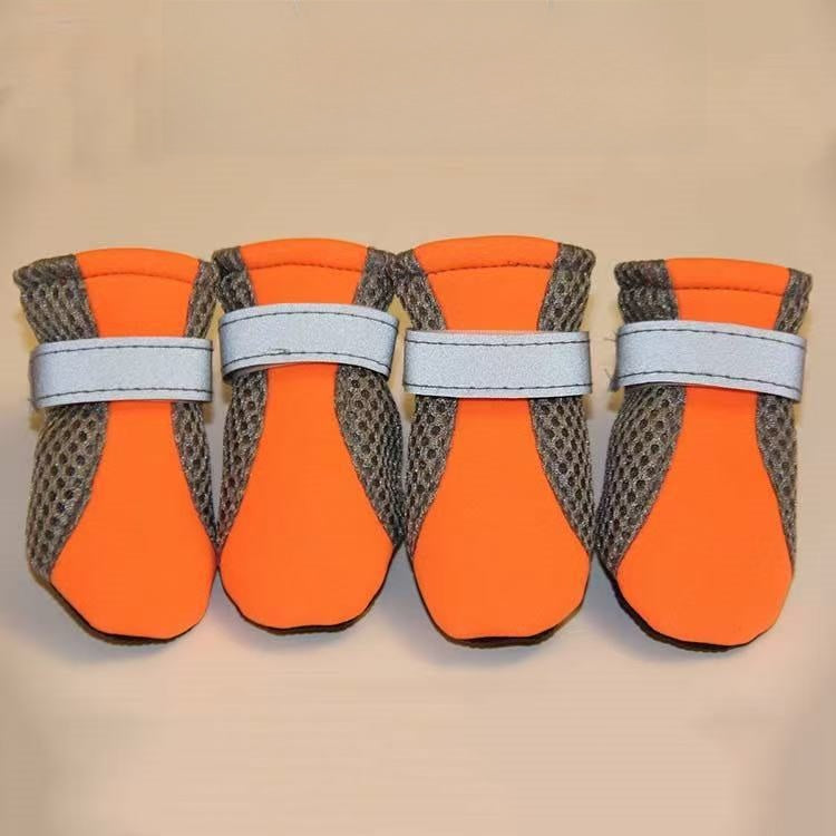 Coloured mesh dog shoe with reflective strap laid flat on a plain surface