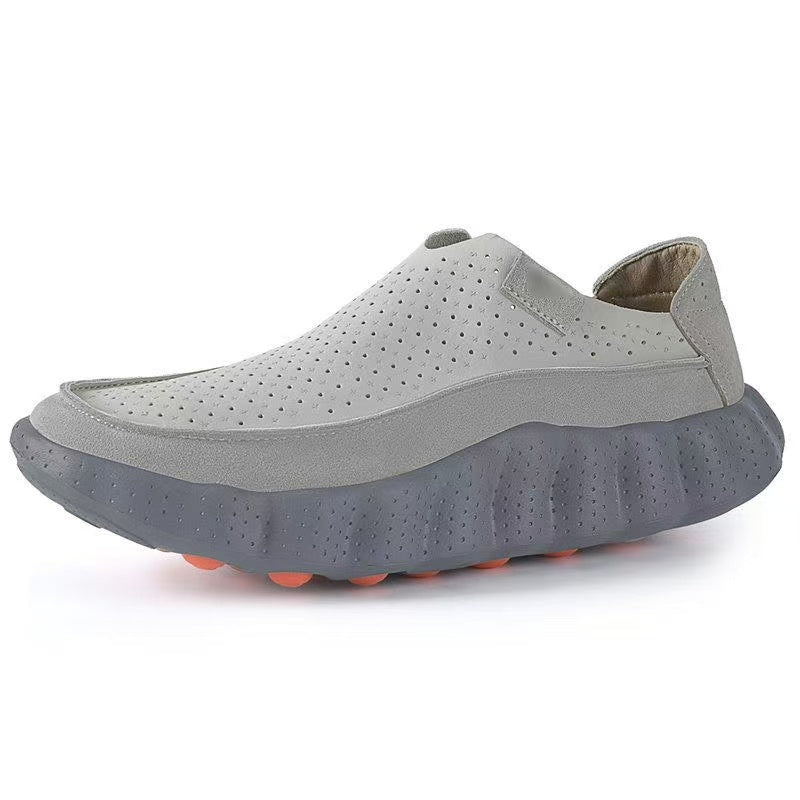 Light gray perforated slip-on loafer with a slate gray scalloped sole and orange tread nubs, side view on white