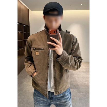 Man in a brown washed cotton jacket with a chest zip pocket, taking a mirror photo in a room with wooden shelves