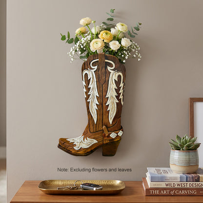 Brown wooden cowboy boot wall vase with cream scroll inlay, holding flowers by a console