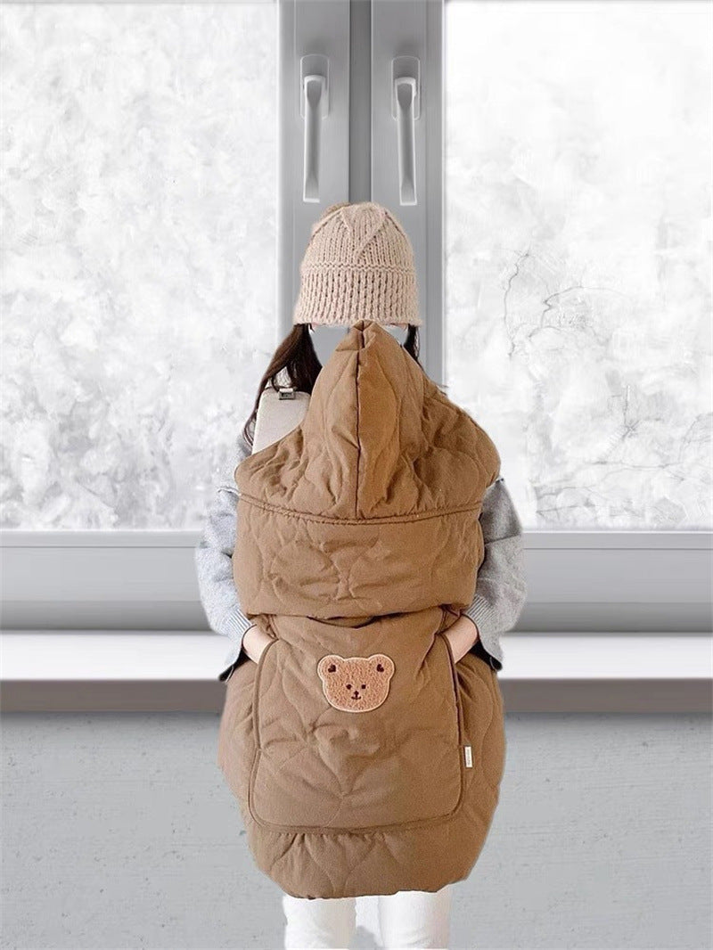 Fold up hood of the quilted baby cape shielding the head from the wind