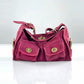 Rose red option: raspberry pink suede hobo bag with two front twist lock pockets on a glossy white surface