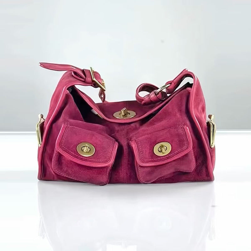 Rose red option: raspberry pink suede hobo bag with two front twist lock pockets on a glossy white surface