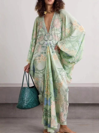 Woman in a light green floral V-neck dress with wide sleeves holding a teal woven tote bag