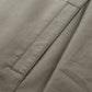 Close view of a slanted side pocket with edge stitching on the khaki cotton fabric of the jacket