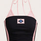 Pink and black halter crop top with side stripes and flag print flat lay