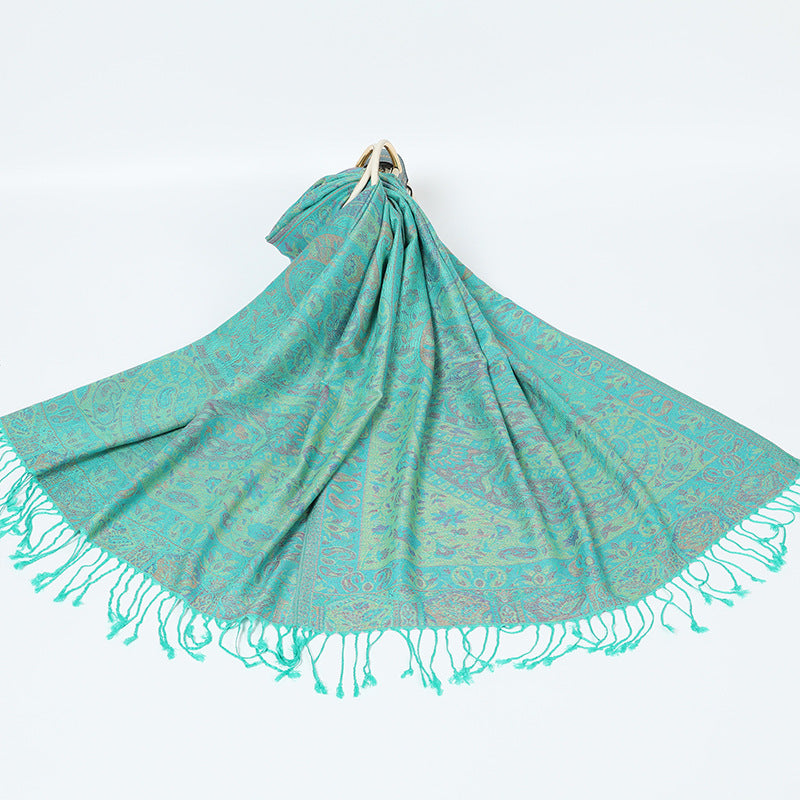 Jade green paisley shawl with turquoise tassels spread on a white background